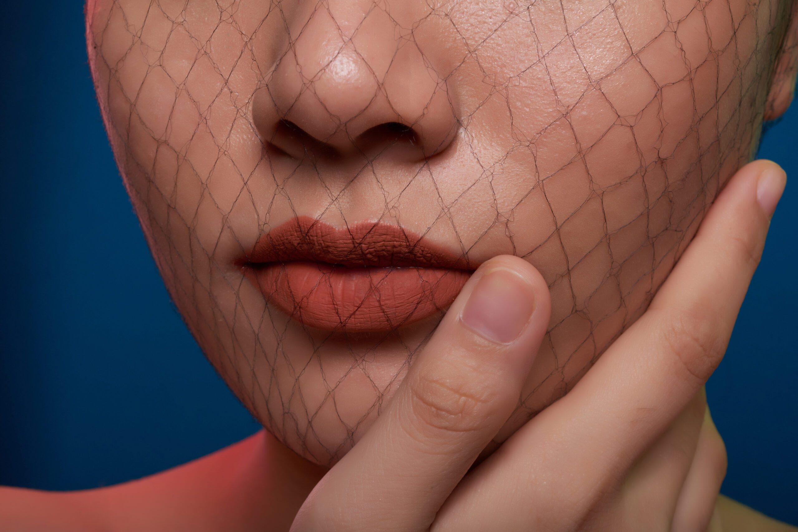 Close-up image of woman with beautiful lips touching her face